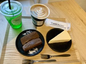 Latte macchiato, einen Melon Soda für Alina, dazu ein Stück Schokokuchen und ein Stück New York Cheesecake